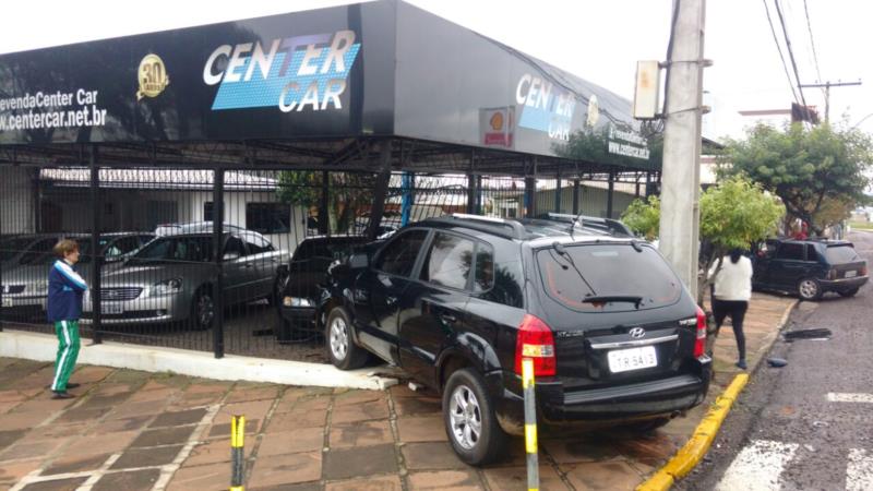 Carro colide em grade de revenda